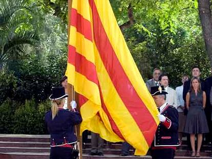 La bandera es izada por dos <i>mossos</i> durante la celebración.