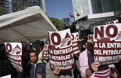 Manifestantes en contra de la reforma energética frente a las mallas que cubren la Cámara de Senadores