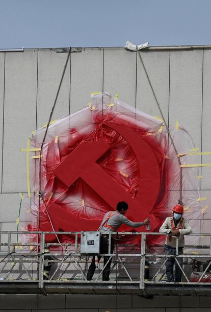Trabajadores repintaban el sábado el emblema del Partido Comunista en la ciudad de Yan’an.