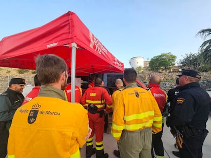Equipos de la Unidad de Defensa contra los Incendios Forestales de la Región de Murcia, este lunes en el puesto de mando, reciben indicaciones para incorporarse en las labores de control del incendio forestal en Tàrbena (Alicante). 
