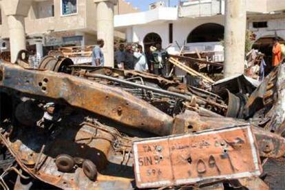 Varios transeúntes observan un coche destrozado en el mercado viejo de Sharm el Sheij.