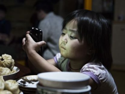 Una niña ve, en Mongolia, una serie de dibujos animados que su padre ha descargado en el móvil.