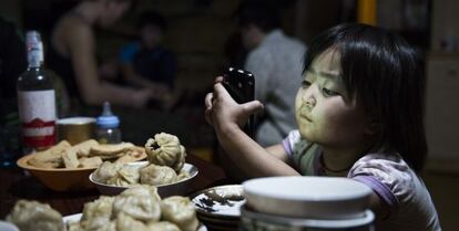 Una niña ve, en Mongolia, una serie de dibujos animados que su padre ha descargado en el móvil.