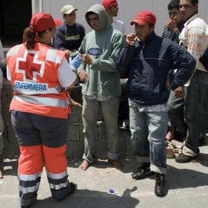 Una voluntaria de Cruz Roja atiende a un grupo de inmigrantes en Almería el pasado sábado.