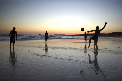 Unos jóvenes juegan al fútbol en una playa de Conil.