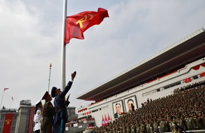 Soldados izan la bandera del Partido Comunista.