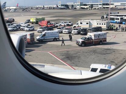 Personal de emergencias este miércoles alrededor del avión de Emirates que está en cuarentena en el aeropuerto JFK de Nueva York. Fotografía tomada por un pasajero desde dentro de la aeronave.