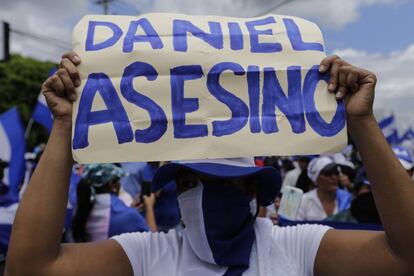 Una manifestante sostiene un cartel contra el presidente Ortega.