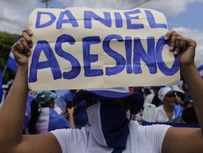 Una manifestante sostiene un cartel contra el presidente Ortega.