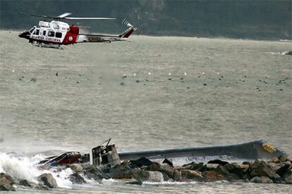Un helicóptero de la Guarda Costera italiana sobrevuela la zona en la que está encallado el buque <i>Margaret</i>.