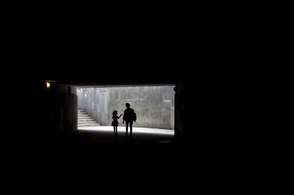 Una mujer camina con una niña por un paso subterráneo en Ereván (Armenia).