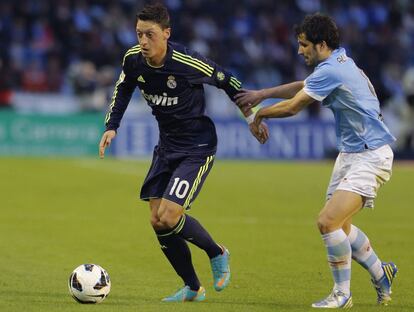 Özil conduce la pelota ante Álex López.