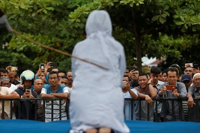 Una multitud de hombres se ríen y graban con sus teléfonos móviles como una mujer acusada de mantener relaciones sexuales fuera del matrimonio recibe latigazos en público, en Banda Aceh (Indonesia). Banda Aceh es la única provincia indonesia que se rige bajo la 'sharia' en Indonesia.