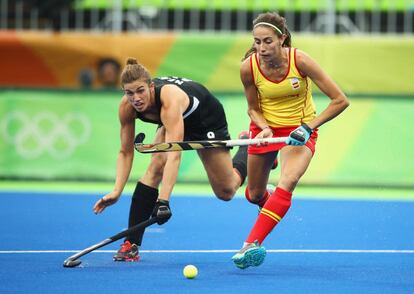 La española Carola Salvatella es perseguida por la neozelandesa Brooke Neal en un partido de hockey sobre césped.