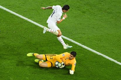 Ángel Di María salta sobre el portero del Real Madrid Thibaut Courtois durante una jugada.