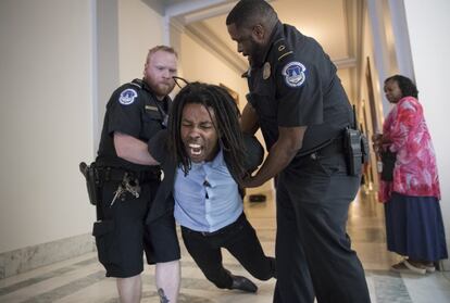 Un total de 80 personas han sido detenidas por su participación en una nueva protesta contra el proyecto de ley presentado por los republicanos para derogar la reforma sanitaria de Barack Obama, conocida como el 'Obamacare'. En la imagen, un policía detiene a un manifestante en el interior del Capitolio, Washington.