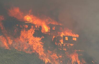 El fuerte viento, de hasta 60 kilómetros por hora, propagó las llamas hacia las zonas habitadas del sur de Valparaíso, donde las temperaturas alcanzaron los 34 grados. En la imagen, el fuego devora varias viviendas de la colina.