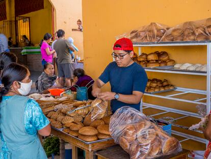 Dos mujeres compran pan en un puesto en un mercado de Oaxaca.