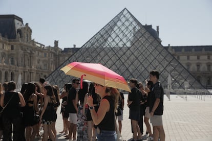 Personas paseando, este martes, durante la ola de calor en París cerca al Louvre.