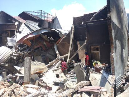 Ambo Pawe y sus dos hijos rebuscan entre las ruinas de su vivienda en el barrio de Balaroa (Palu).