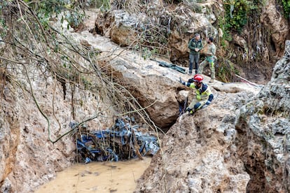 Unos operarios junto a restos arrastrados hasta el arroyo de Letur.