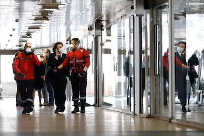 Autoridades com máscaras caminham ao lado de um ônibus da cidade italiana de Milão que ficou em quarentena após a detecção de um caso suspeito de coronavírus.