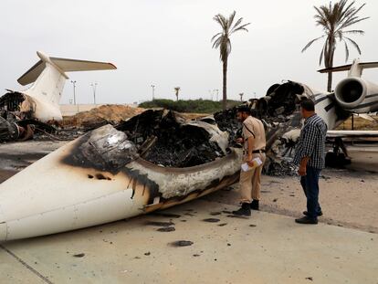 Un policía inspecciona un avión civil alcanzado por las tropas de Jalifa Hafter el 10 de mayo en el aeropuerto de Mitiga, en Trípoli.