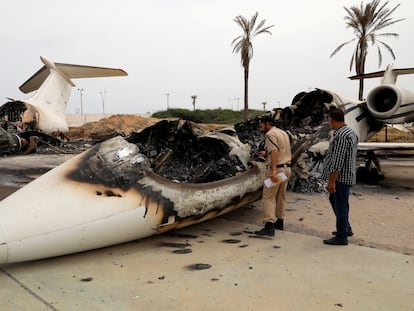 Un policía inspecciona un avión civil alcanzado por las tropas de Jalifa Hafter el 10 de mayo en el aeropuerto de Mitiga, en Trípoli.