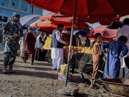 Un talibán patrulla armado en un mercado al aire libre de Kabul.