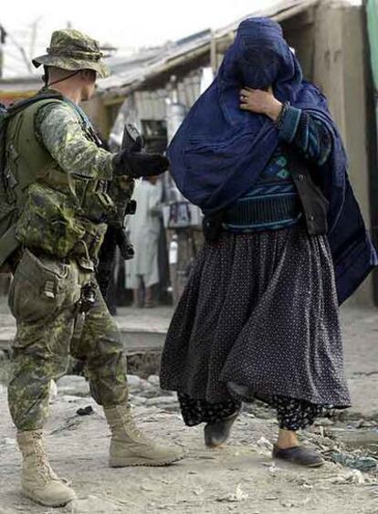 Un soldado canadiense hace indicaciones a una mujer en un control en Kabul.