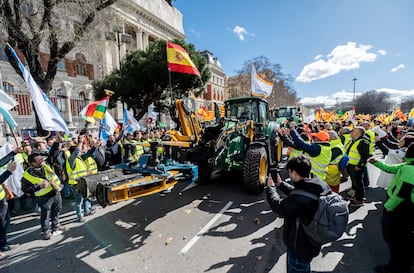 Centenares de agricultores aplauden la llegada de varios tractores al Ministerio de Agricultura, este lunes. 