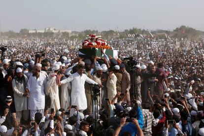 Una multitud traslada el ataúd de Junaid Jamshed, envuelto en la bandera nacional, una estrella del pop convertido en clérigo musulmán evangélico, que murió en un accidente aéreo, en Karachi (Pakistán).