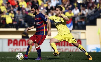 Arda Turan disputa un balón con Soldado (d).