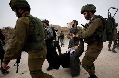 Tropas israelíes detienen a un manifestante palestino cerca de Ramala (Cisjordania).