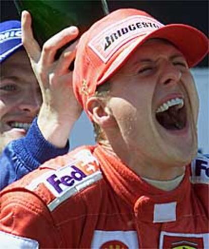 Ralf Schumacher echa champaña por la espalda de su hermano Michael en el podio del GP de Francia.