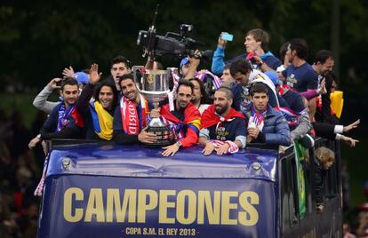 Atl&eacute;tico Madrid&#039;s players celebrate on an open bus at the Neptuno square in Madrid on Saturday.