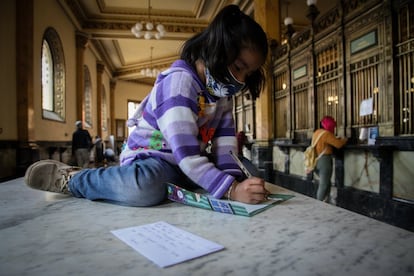 Una niña escribe su carta dirigida a los Reyes Magos a las oficinas de Correos de México.