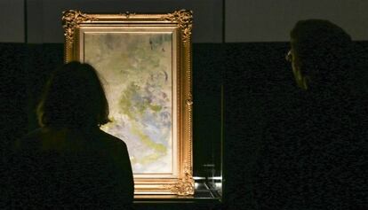Dos personas observan el cuadro nunca visto de Claude Monet, en el centro Ideal. 