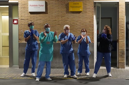 Health workers at a hospital in Seville applaud outside the emergency ward.