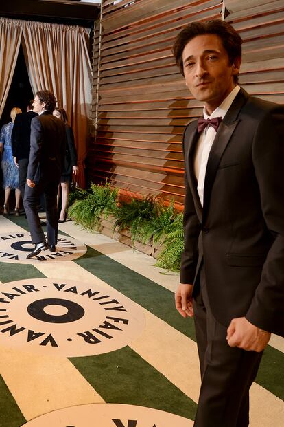 Adrien Brody mira desconcertado a cámara mientras al fondo Orlando Bloom posa ante los fotógrafos.