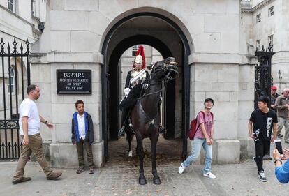 Turistas junto a un miembro de la Guardia de la Reina en Londres (Reino Unido).