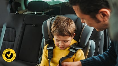 Un padre poniéndole el cinturón a su hijo en el coche.