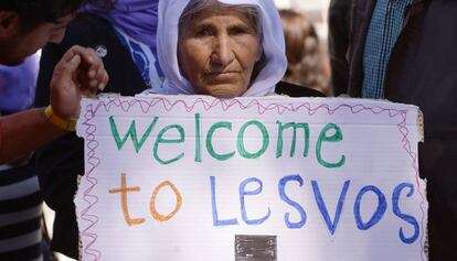 Una dona sosté un missatge de benvinguda al Papa en un camp de refugiats de Lesbos.
