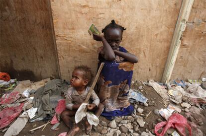 Un par de niños esperan el reparto de comida en la ciudad de Adén.