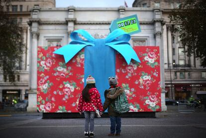 Unos niños miran un gigantesco regalo de navidad situado en Marble Arch de Londres que celebra la inauguración de la tienda Cath Kidston, la más grande del mundo, 5 de diciembre de 2013.