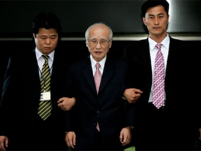 Dos agentes de la Fiscalía General escoltan a Kim Woo-Choong, fundador de Daewoo.