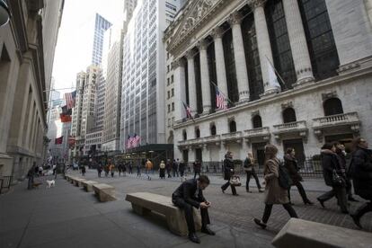 Trabajadores de Wall Street pasan por delante de la Bolsa de Nueva York.