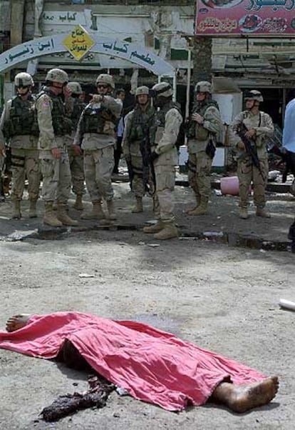 Soldados de EE UU ante el cadáver del terrorista suicida, en Bagdad.
