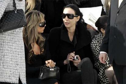 Wren Scott, con un anillo de compromiso, charla con Victoria Beckham durante un desfile de Chanel en París.