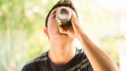 A young man drinking a can.